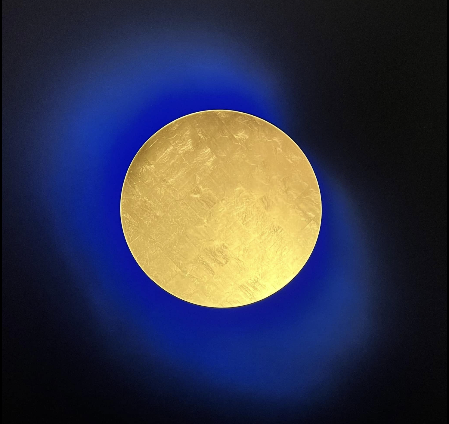 A golden disc glowing against deep blue